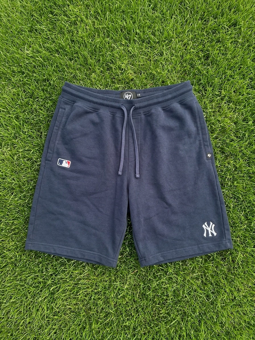The same navy sweat shorts re-shot flat and squared on green grass