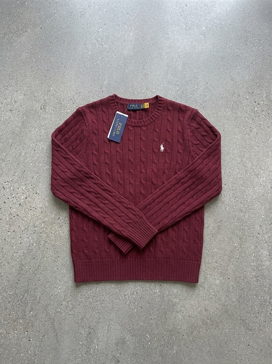 The same burgundy cable-knit Polo Ralph Lauren jumper re-shot flat and centred on grey stone
